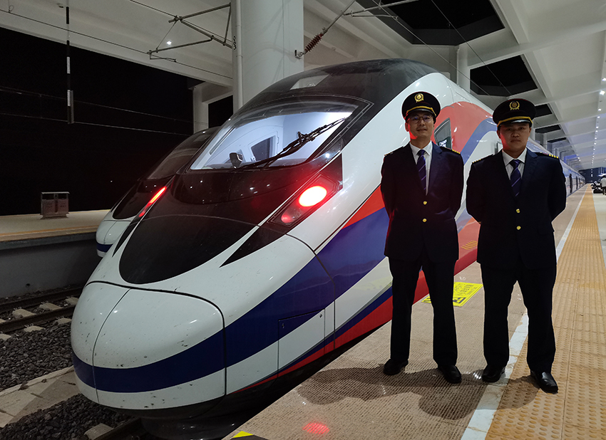 劉銀能（右一）與中國師父鄔俊鴻在動(dòng)車組前合影。受訪者供圖